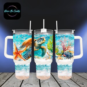 May include: Three insulated tumblers with white handles and straws. Each tumbler features a vibrant underwater scene with a sea turtle, starfish, coral, and sand. The design includes the text "Dixie Be Crafty" in a circular logo.