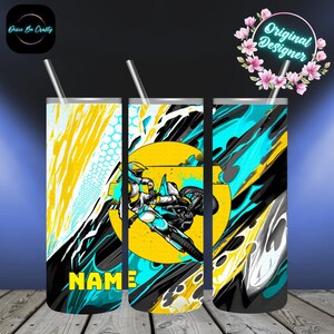 May include: Three stainless steel tumblers with lids and straws. Each tumbler features a vibrant design with a motocross rider in action, set against a yellow and teal background. The design includes the word "NAME" in yellow. The tumblers are decorated with abstract splashes.