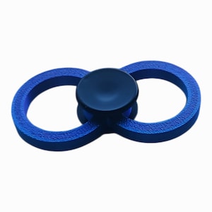 May include: A blue bottle stopper with a textured infinity-shaped design. The center features a dark blue, circular cap. The stopper is designed to fit snugly into a bottle opening.