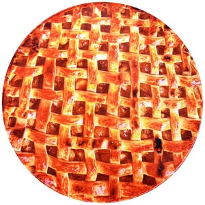 May include: A round, golden brown apple pie with a lattice crust. The pie is a close-up and the crust is in focus.