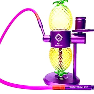 May include: Purple pineapple-shaped glass water pipe with a purple metal base and a pink silicone hose. The pipe has a removable bowl and a diffuser. The base has the text "Quality Detail INC" on it.