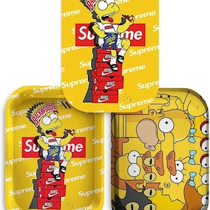 May include: Three yellow rolling trays with cartoon graphics. One tray features Bart Simpson with a "Backwoods" crown, "Supreme" and "Nike" branding. Another tray has the same Bart Simpson design. The third tray has a design of various Simpsons characters.