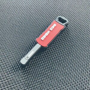May include: A red and black screwdriver keychain with the words "Razer Gear" printed on the red handle.