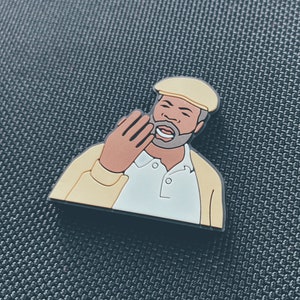 Puede incluir: Un personaje de dibujos animados amarillo y blanco con una gorra negra y una camisa blanca. El personaje sonríe y tiene una mano levantada a la mejilla.