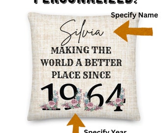 May include: Personalized throw pillow with a beige linen background, featuring the text "Silvia Making the World a Better Place Since 1964" in black lettering. The year is decorated with floral accents.