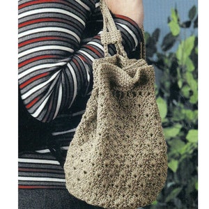 May include: A brown crocheted tote bag with a pattern of small squares. The bag has two straps and is being carried by a person wearing a striped shirt.