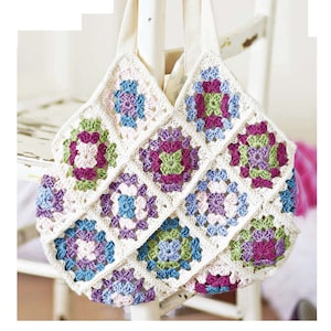 May include: A crocheted tote bag with a white background and colorful granny squares in shades of pink, green, blue, and purple.