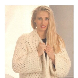 Peut inclure: Un cardigan blanc en tricot avec un col châle et des manches longues. Le cardigan est fait avec un fil épais et a une coupe ample.