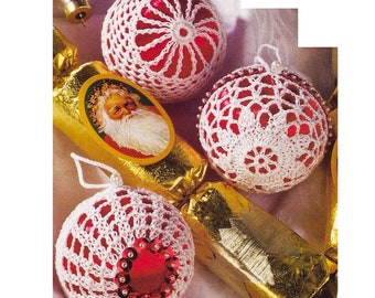 May include: Three white crocheted Christmas ornaments with red centers. The ornaments are decorated with sequins and are sitting on a gold wrapping paper tube.