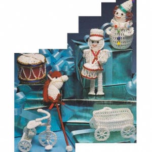 May include: Crocheted Christmas ornaments featuring a drummer boy, a clown, a rocking horse, a wagon, and a tricycle. The ornaments are white with red, blue, and gold accents.