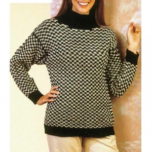 May include: A black and white patterned turtleneck sweater with a mock neck. The sweater has a black trim around the neck, cuffs, and hem.
