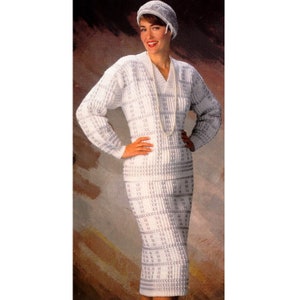 Puede incluir: Un vestido blanco de ganchillo con un patrón geométrico y un sombrero a juego de ganchillo blanco. El vestido tiene un escote en V y mangas largas.