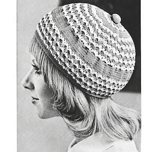 May include: A white and grey crocheted beret with a textured design.