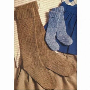May include: Two pairs of knitted socks. One pair is knee-high in a light brown color with a diamond pattern. The other pair is ankle-high in a light blue color. The socks are displayed on a neutral background.
