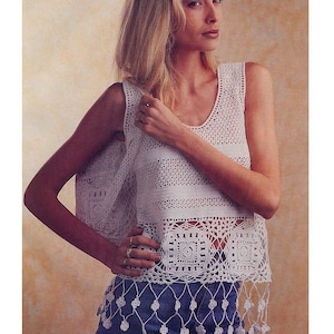 May include: White crochet top with a square pattern and fringe trim. The top is sleeveless and has a scoop neck.