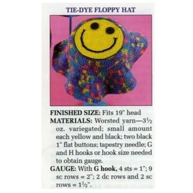 Puede incluir: Un sombrero floppy te&ntilde;ido anudado con una gran carita sonriente amarilla. El sombrero est&aacute; hecho de hilo jaspeado en tonos de azul, morado y amarillo. El texto "TIE-DYE FLOPPY HAT" est&aacute; en la parte superior. El sombrero se adapta a una cabeza de 48 cm.