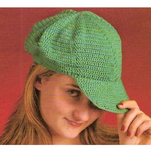 May include: A green crocheted baseball cap with a curved brim. The cap is made with a simple stitch pattern and has a relaxed, casual look.
