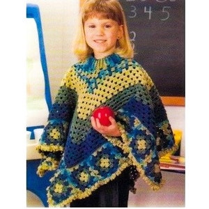 May include: A young person wearing a colorful crocheted poncho with blue, yellow, and green accents. The poncho has a fringed edge and a geometric pattern.