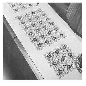 May include: Two crocheted table runners with a floral design. The runners are white with a dark brown centre in each flower.