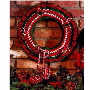 May include: A crocheted Christmas wreath made with red, white and green yarn. The wreath is decorated with small bells and has a red, white and green yarn bow.