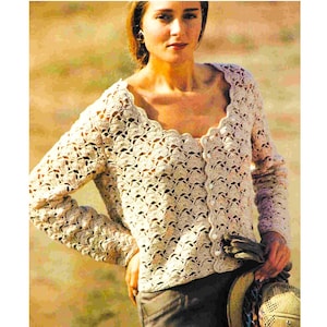 Könnte beinhalten: Eine gehäkelte Strickjacke mit einem gewellten Ausschnitt und Knöpfen. Die Strickjacke ist in Cremefarben gehalten und hat ein zartes, durchbrochenes Muster.