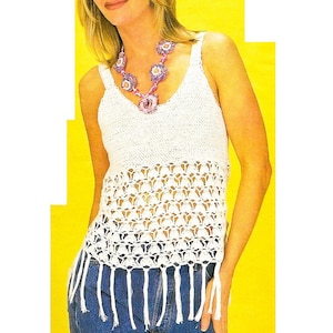 Op de afbeelding: Wit gebreid tanktop met een franje zoom. Het top heeft een v-hals en is mouwloos. Het model draagt een ketting met roze en paarse bloemen.