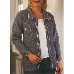 Könnte beinhalten: Ein grauer Häkelcardigan mit weißen Nähten. Der Cardigan hat einen Knopfleistenverschluss und einen Kragen.