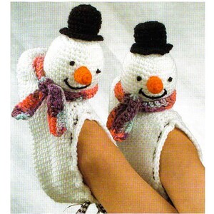 May include: A pair of white crocheted snowman hand warmers with black hats, purple and pink scarves, and orange noses.