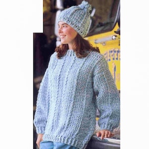 May include: A light blue crocheted sweater with a cable knit pattern and a matching light blue crocheted hat with a white pom pom.
