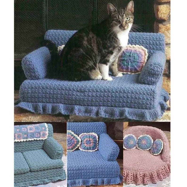 K&ouml;nnte beinhalten: Ein geh&auml;keltes Katzenbett in Form eines Sofas mit einer Katze darauf. Das Sofa ist blau und hat einen gekr&auml;uselten Rand. Auf dem Bild sind drei kleinere geh&auml;kelte Sofas zu sehen, eines blau, eines rosa und eines blau mit einer wei&szlig;en Decke.