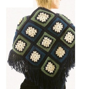 May include: A crocheted shawl with a geometric pattern in shades of blue, green, and white. The shawl has a fringe border.