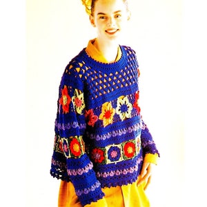 May include: A blue crocheted sweater with colorful flower accents. The sweater has a round neckline and long sleeves.