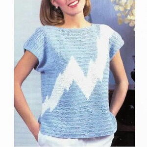 May include: A light blue crochet top with a white crocheted lightning bolt design.