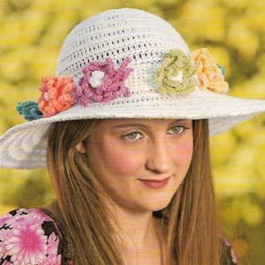 May include: A white crocheted sun hat with a wide brim and colorful crocheted flowers around the crown.