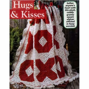 May include: A white and red crocheted afghan with the words "Hugs & Kisses" at the top. The afghan features large red XOX designs. The text "Soften anyone's heart with this plush, cuddly granny square afghan stitched in fuzzy worsted" is also visible.