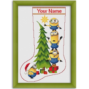 May include: A Christmas stocking with a red and white border featuring a stack of three Minions holding a Christmas tree with a star on top. The stocking has the text "Your Name" at the top and a Minion wearing a Santa hat at the bottom.
