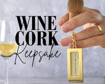 Op de afbeelding: Gouden wijnkurk-sleutelhanger met een ketting en een rechthoekig label met de tekst "40th Year Anniversary" en "occasion".