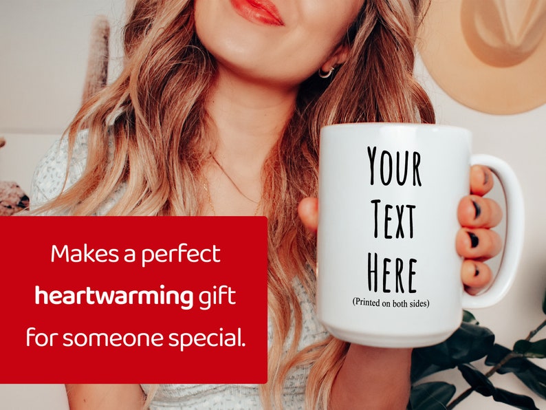 Peut inclure: Mug en c&eacute;ramique blanche avec le texte "YOUR TEXT HERE" imprim&eacute; en noir. La tasse a une grande anse et est tenue par une personne. Le texte "Makes a perfect heartwarming gift for someone special" est sur fond rouge.