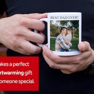 Pu&ograve; includere: Tazza in ceramica bianca con la scritta "BEST DAD EVER!" e una foto di un padre e un bambino. La tazza &egrave; tenuta da una persona che indossa una camicia nera e un orologio nero.
