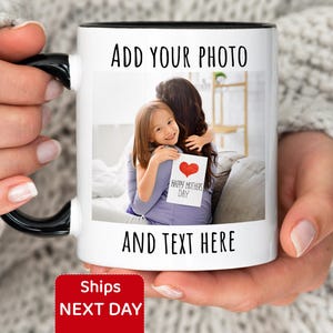 May include: White ceramic mug with a black handle and rim, featuring a photo of a mother and child hugging, holding a "Happy Mother's Day" card. The mug has the text "ADD YOUR PHOTO" and "AND TEXT HERE".