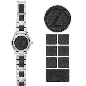May include: A silver-toned wristwatch with a black textured center link bracelet and a circular watch face featuring a black textured background with a stylized letter L. Beside the watch are seven black textured square and rectangular inserts.