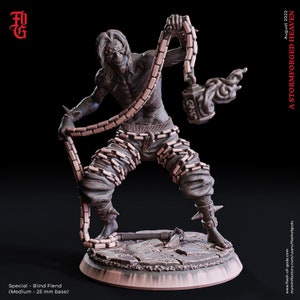 May include: A detailed miniature figure of a blind fiend, a monstrous creature with chains wrapped around its body and a menacing expression. The figure is painted in a muted brown color and stands on a circular base.