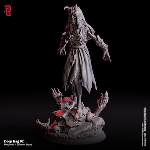 May include: A gray Deep Hag 02 figurine with a 25 mm base. The figure is a monster with long hair, horns, and a tattered dress, standing on a rocky base with skulls and skeletal hands. The text "Deep Hag 02" and "Medium - 25 mm base" is visible.