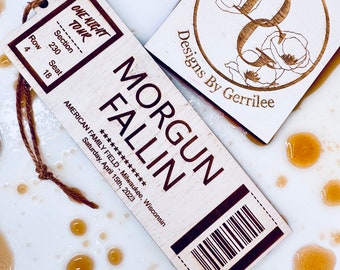 Könnte beinhalten: Ein Holzticket mit dem Text "Morgun Fallin" und "One Night Tour" darauf gedruckt. Das Ticket enthält auch den Text "American Family Field - Milwaukee, Wisconsin" und "Saturday, April 15th, 2023".