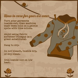 May include: A light blue hoodie with a brown pocket and a floral pattern. The hoodie has a logo that says "BLUME CORN" and "ARTBY THREADS". The text "How to care for your art wear" is written in brown text on a beige background. The text describes how to care for the hoodie, including washing, drying, and ironing instructions.