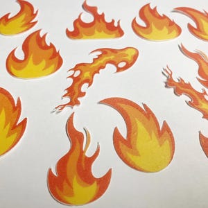 May include: A set of ten orange and yellow flame stickers. The flames are in various shapes and sizes, with some having a more pointed tip and others having a more rounded tip.