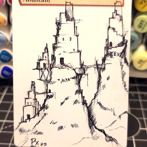 May include: A hand-drawn illustration of a mountain landscape on a white card. The card features the word "Mountain" at the top. The artwork depicts a series of interconnected structures on a rocky terrain, rendered in black ink. Signed "Px 25".