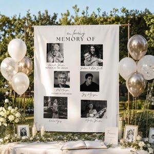 May include: A white fabric memorial banner featuring the text "in loving MEMORY OF" and six black and white photographs of individuals with their names printed below, displayed on a copper stand with white and metallic gold balloons.
