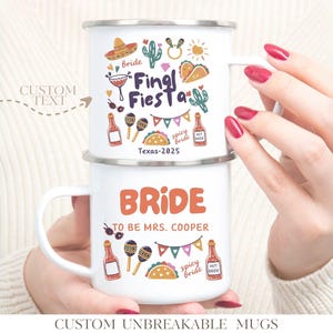 Puede incluir: Dos tazas de esmalte blanco apiladas. La taza superior dice "Final Fiesta" con ilustraciones festivas. La taza inferior dice "Bride to be Mrs. Cooper". Ambas tazas tienen un asa y son sostenidas por una persona.