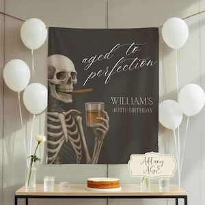 Può includere: Banner di compleanno "Aged to perfection" con uno scheletro con sigaro e drink. Il banner presenta il testo "Aged to Perfection" e "40° compleanno di William". Sono presenti anche palloncini bianchi e una torta.